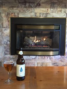 Good River Beer next to a fireplace.